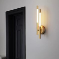 a wall light that is on the side of a wall next to a black door