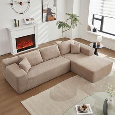 a living room with a large sectional couch and fire place in the corner, on top of a hard wood floor