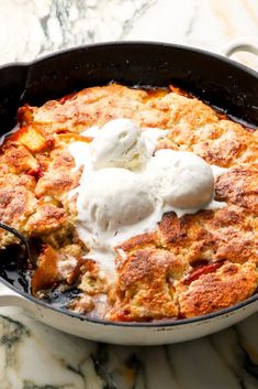 a skillet filled with food on top of a marble counter