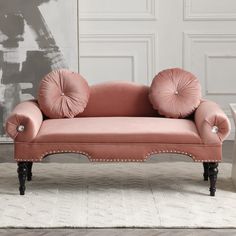 a pink couch sitting on top of a white rug