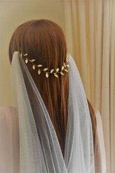 a woman wearing a veil with gold leaves on it