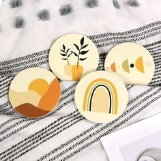 three buttons with designs on them sitting on a bed