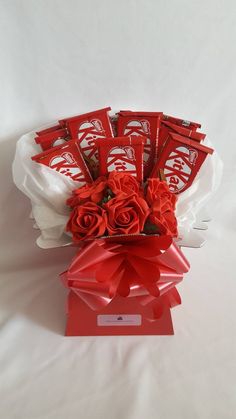 a bouquet of roses and chocolates in a red gift box on a white background