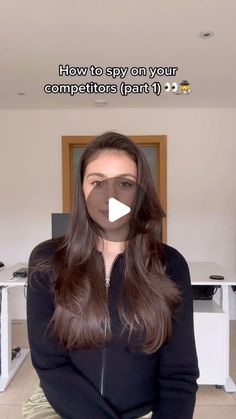 a woman with long brown hair standing in front of a computer desk