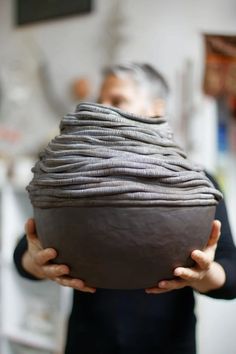 a woman holding a bowl in front of her face