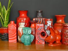 there are many different vases on the shelf next to each other, including one with an owl