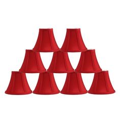 a group of red lampshades sitting next to each other on a white background