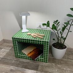 a green tiled table with a potted plant next to it