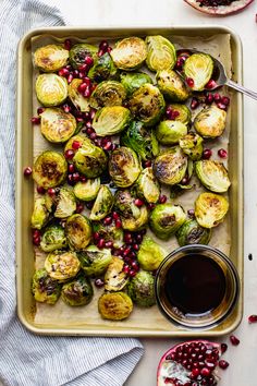 brussel sprouts and pomegranates on a baking sheet