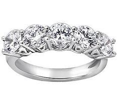 a wedding ring with five stones on the side and four clawed shants in white gold