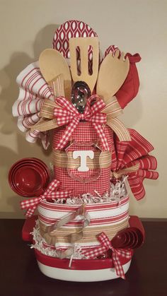 a red and white basket with utensils in it sitting on top of a table