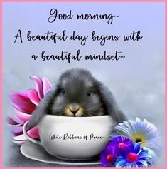 a bunny is sitting in a cup with flowers on the side and a quote about good morning