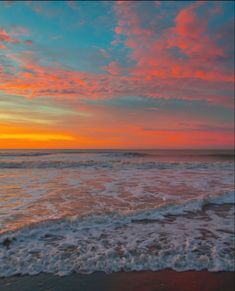 the sun is setting over the ocean with waves coming in