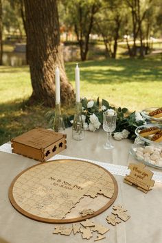 a wooden board game sitting on top of a table next to a plate of food