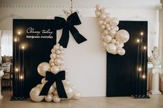 balloons are arranged in the shape of a letter on display at a corporate event with black and white decor