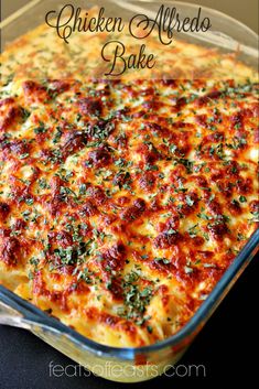 chicken alfredo bake in a glass casserole dish with fresh herbs on top