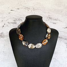 "This unique animal print gemstone necklace was hand beaded using large 30x20mm oval shaped agate gemstones in shades of brown, cream, and taupe, separated by faceted complimentary Czech glass beads. It measures approximately 17 inches in length and is secured with a silver clasp. This is the perfect addition to your wardrobe for a touch of classic animal print!  It never goes out of style. Length can be adjusted if needed - just ask! Check out the matching earrings: https://www.etsy.com/listing Brown Oval Natural Stone Necklace, Handmade Brown Oval Necklace, Animal Print Jewelry, Wooden Bead Jewelry, Brown Beaded Necklace, Brown Gemstone, Brown Necklace, Wood Bead Necklace, Color Necklace