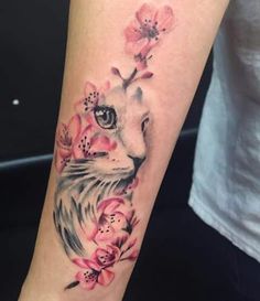 a woman's arm with a cat and flowers on it