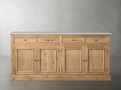 a white counter top sitting on top of a wooden cabinet next to a gray wall