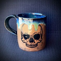 a ceramic mug with a skull painted on it