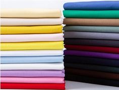 a stack of different colored sheets on top of each other with one folded in the middle