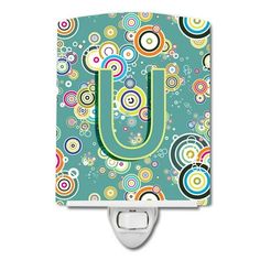 a night light with the letter u on it and colorful circles around it in green