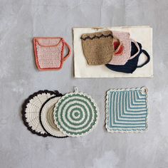 crocheted coasters and pot holders are laid out on a gray table top