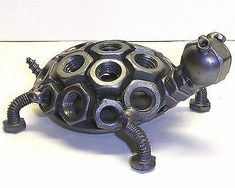 a metal turtle sitting on top of a white table