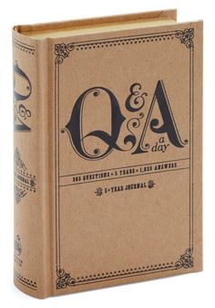 a brown book with the words q and a on it, sitting in front of a white