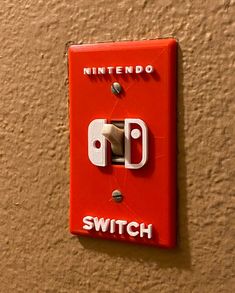 a red switch is mounted to the side of a wall with white lettering on it