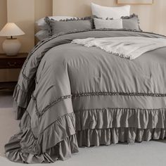 a bed with ruffled bedspread and pillows