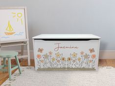 a child's toy chest with flowers painted on it