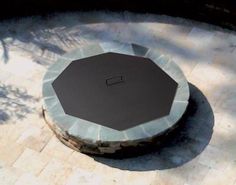 a stone fire pit sitting on top of a sidewalk