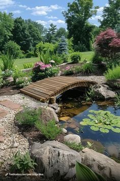 a wooden bridge over a small pond surrounded by rocks and water lilies in a garden