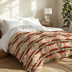 a bed in a bedroom with white sheets and pillows