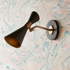 a wall light that is on the side of a wall with marbled walls behind it