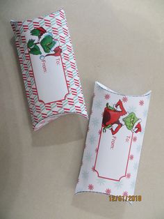 two christmas gift bags sitting on top of a table