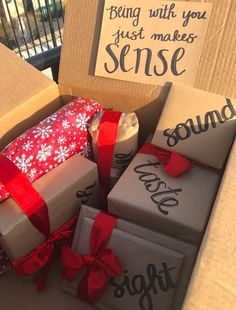 several boxes with wrapped presents sitting on top of each other in front of a sign that says, being with you just makes sense
