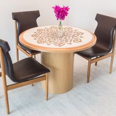 a round table with chairs around it and a flower in the center, on a white carpeted floor