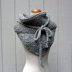 a white mannequin wearing a gray knitted scarf