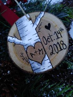 a wooden ornament that has been decorated with the date and heart on it