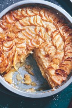 an apple pie in a pan with one slice missing