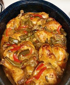 a pan filled with chicken and peppers on top of a stove