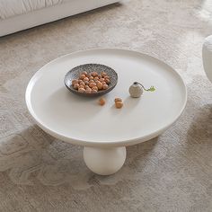 a white table with a bowl of nuts on it