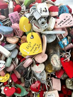 lots of love locks and hearts attached to each other with words written on the keys