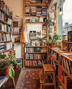 a bookshelf filled with lots of books next to a window