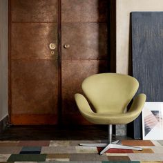 an egg chair sitting in front of a wooden door