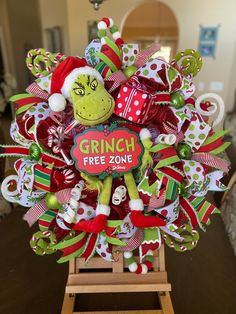 a christmas wreath with the grinch free zone on it and a green stuffed animal