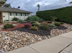 a house with rocks and plants in front of it