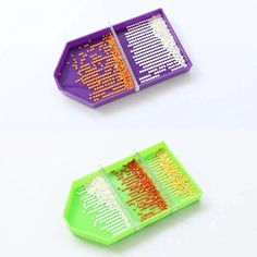 two plastic trays filled with different types of beads on top of a white table